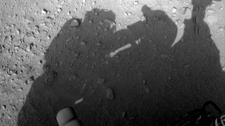 shadow-of-astronaut-cleaning-rover-768x432.png